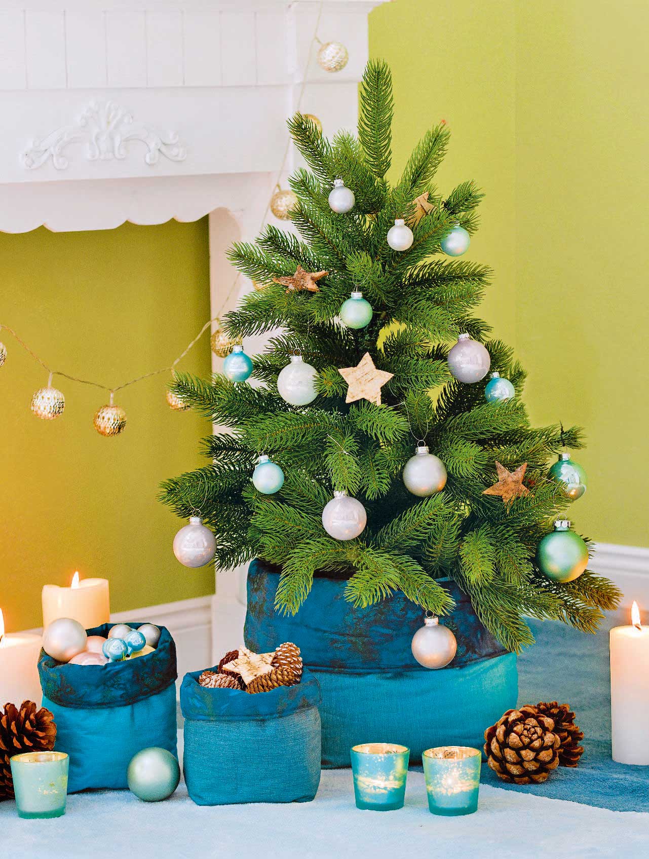 Weihnachtsbaum mit goldenen Sternen, blauen und silbernen Kugeln. Stilvolle, festliche DIY-Verzierungen.