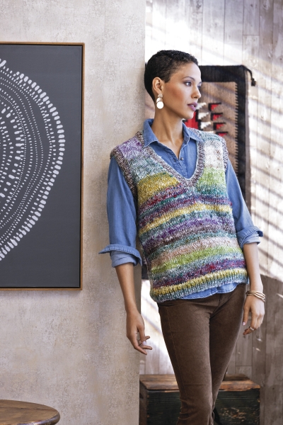 Bunt gestreifte, handgemachte Strickweste, lässig über blauer Bluse. Modisch, handmade, DIY.