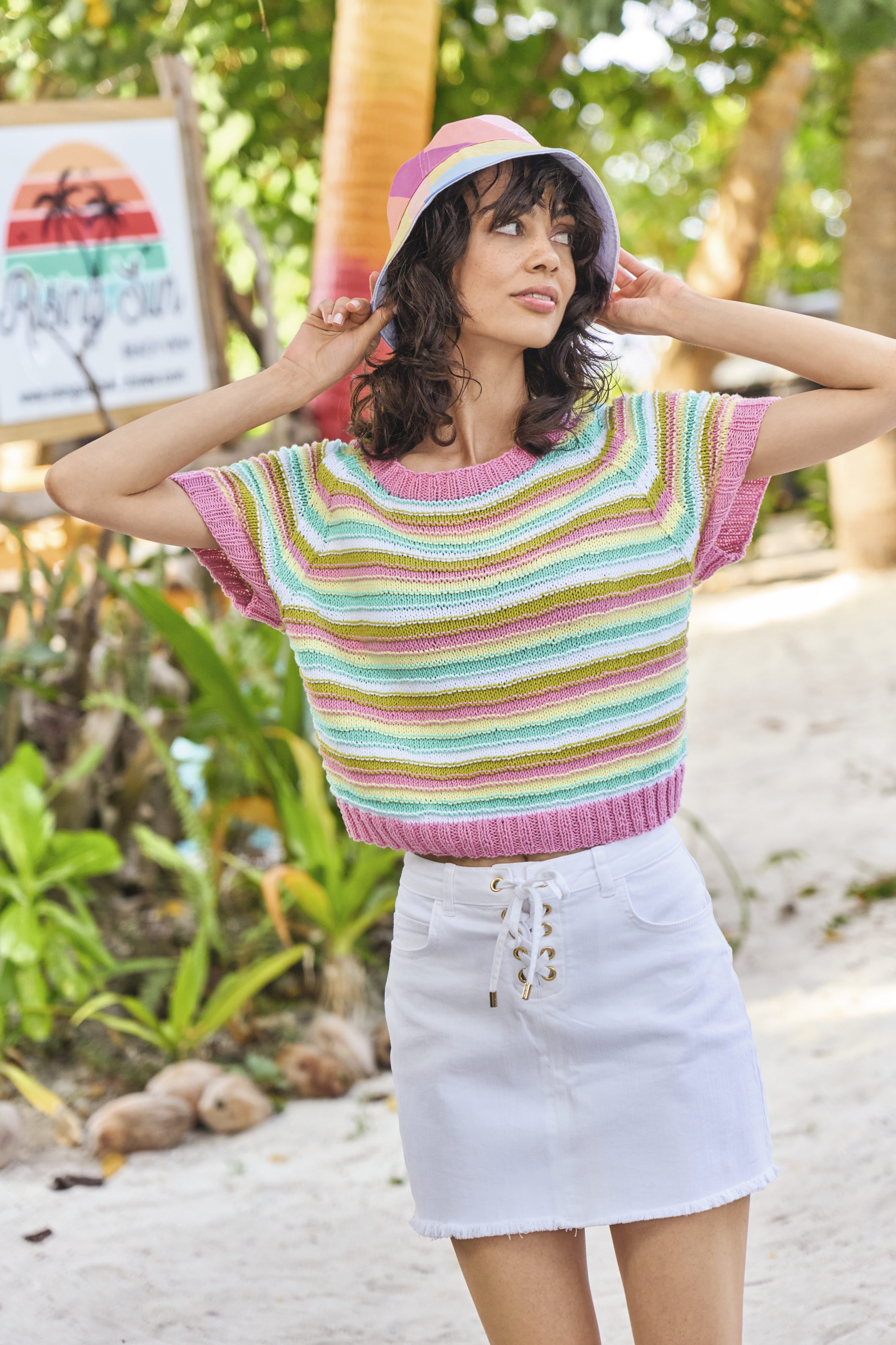 Bunt gestreifter, selbstgemachter Pulli, lebendige Pastelltöne. Weißer Rock mit Schnürung, lässiger Stil.