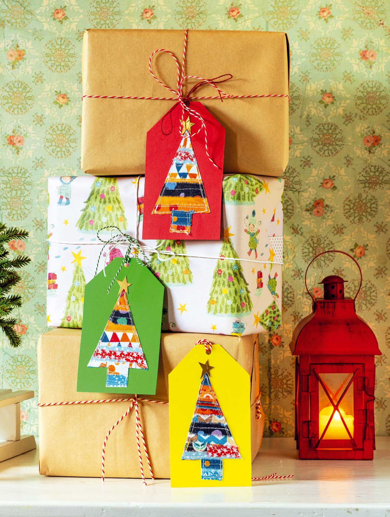 Geschenkanhänger mit handgemachten, bunten Dreiecken in Weihnachtsbaum-Form auf rotem, grünen und gelbem Karton.