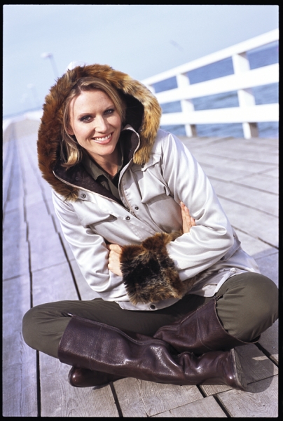 Silberne Jacke mit Pelzkapuze, modisch und funktional. Braune Stiefel, elegant und robust. Winterart.