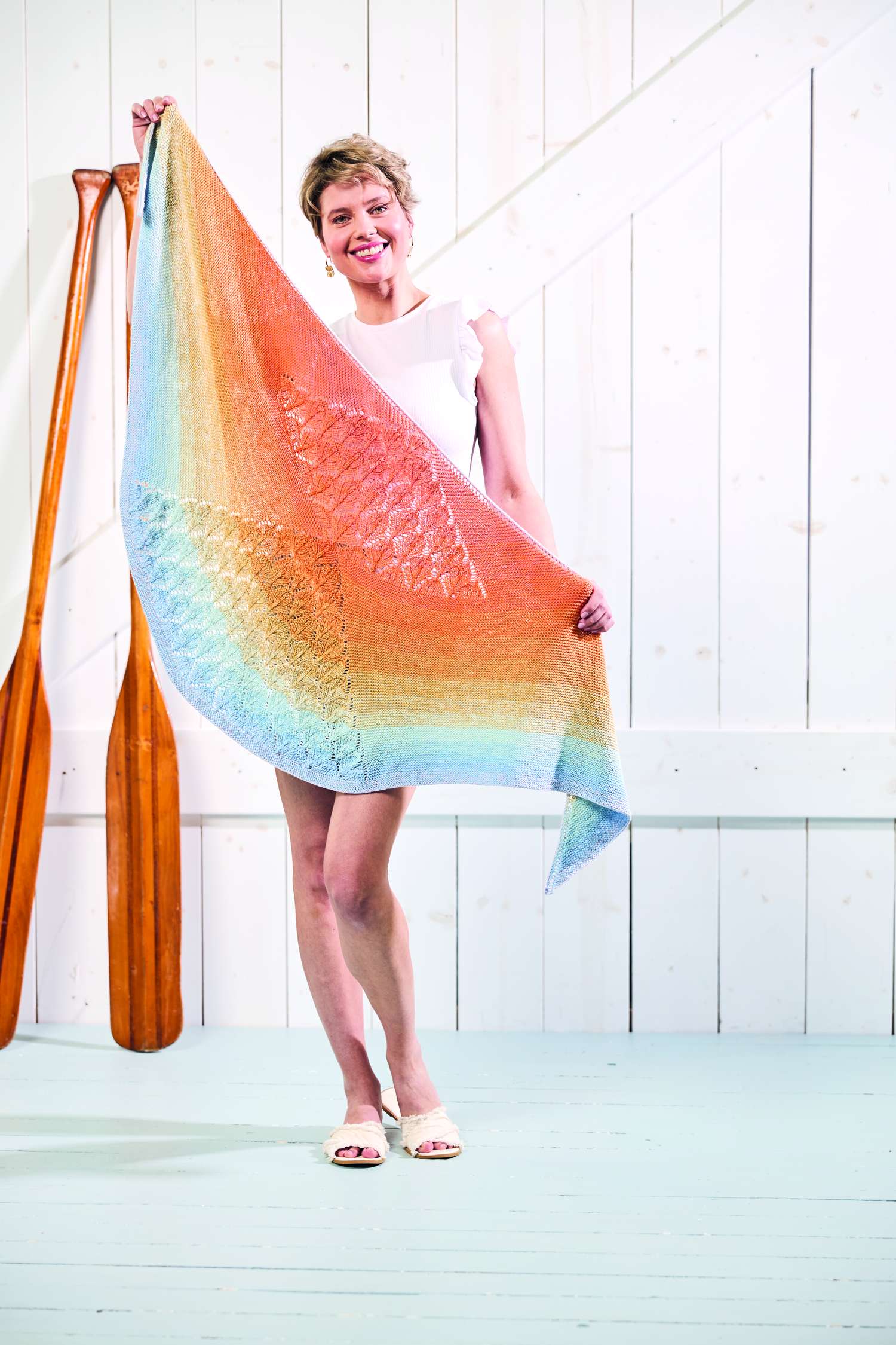 Modischer, handgemachter Schal mit sanften Regenbogenfarben und zartem Strickmuster.