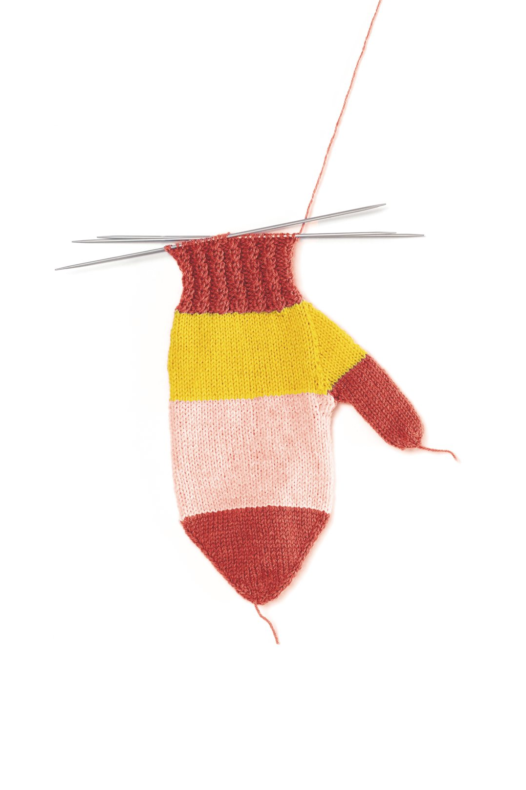 Modische handgestrickte Fausthandschuhe in rot, gelb und rosa. Farbblockmuster mit grobem Strickrippenbündchen.