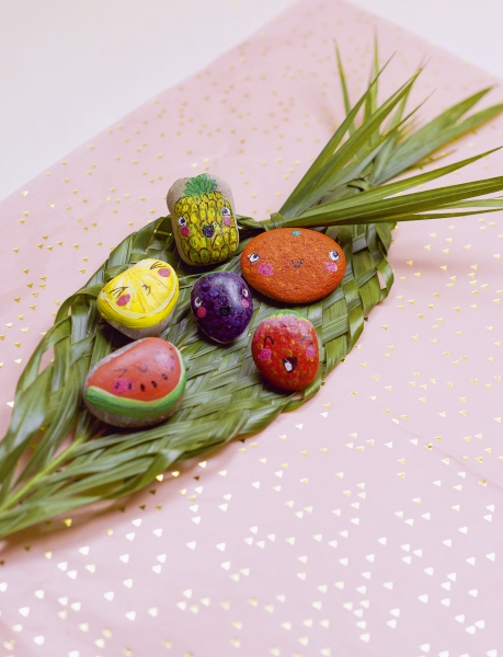 Bunte DIY-Steine bemalt als Früchte; kreativ, handgemacht mit detailreichen Mustern, modisch arrangiert.