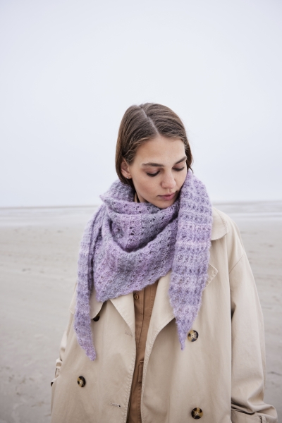 Modischer lila Strickschal, handgefertigt, über beiger Oversized-Mantel. Stilvoll, gemusterter Texturakzent.