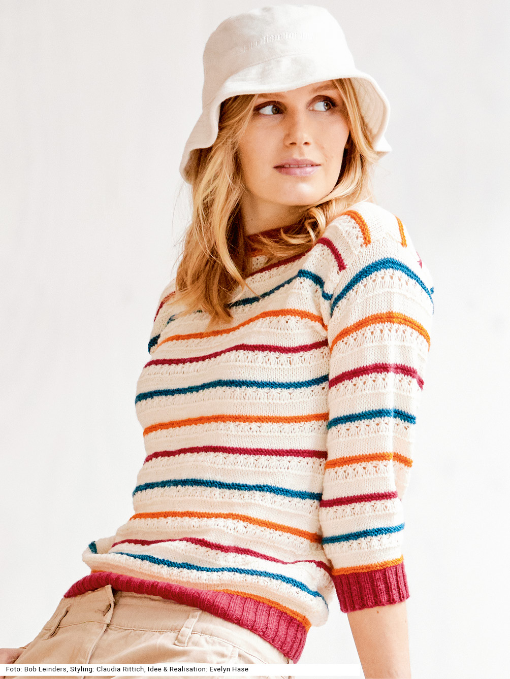 Modellansicht Bild 1: Weißer Pulli mit schmalen Streifen in Rot, Petrol und Orange