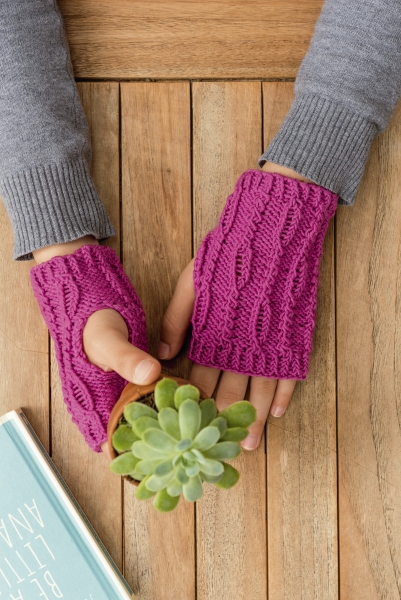 Selbstgemachte pinke Fingerlose-Handschuhe mit Zopfmuster, kreativ und stilvoll gestaltet.