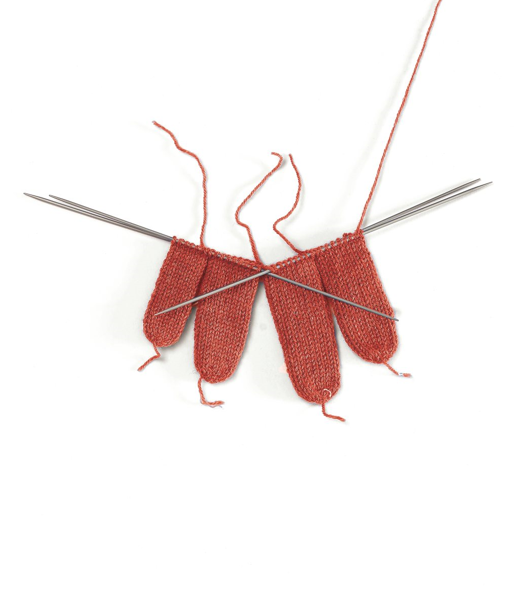 Handgemachte, rot gestrickte Muster, feine Struktur; DIY-Charme; elegante Handarbeit mit Nadeln.