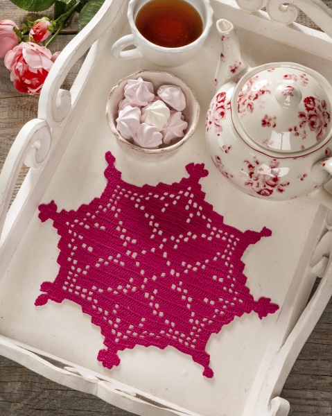 Pinkes, filigranes Häkelmuster, quadratisch arrangiert, wirkt modisch und kunstvoll, ideal als Tischdeko.