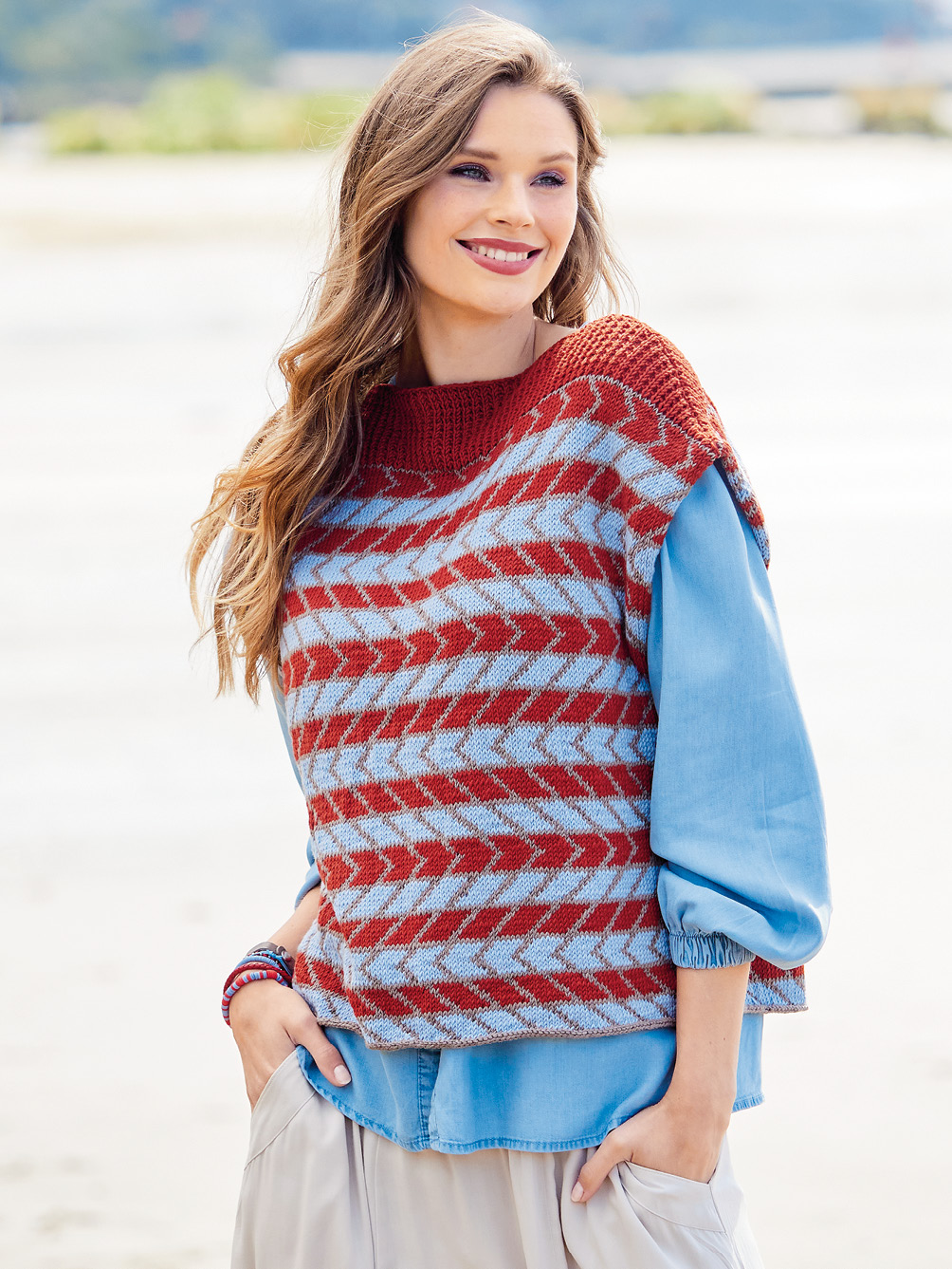 Modellansicht Bild 1: Oversize Pullunder im Jacquardmuster in Rot, Taupe und Hellblau