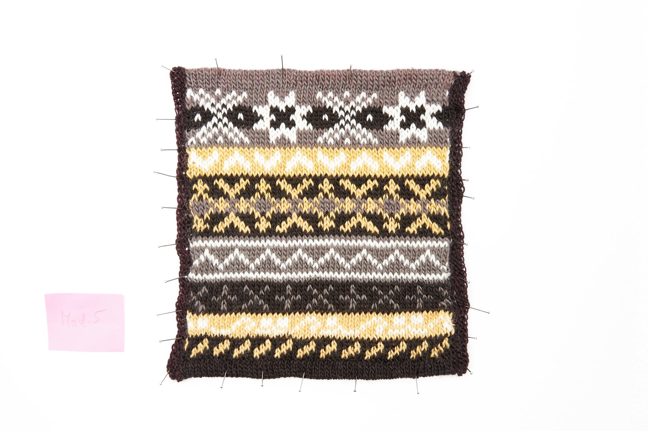 Modische, handgemachte Strickarbeit in Braun-Gelb-Tönen mit geometrischen Mustern. Retro-Charme.