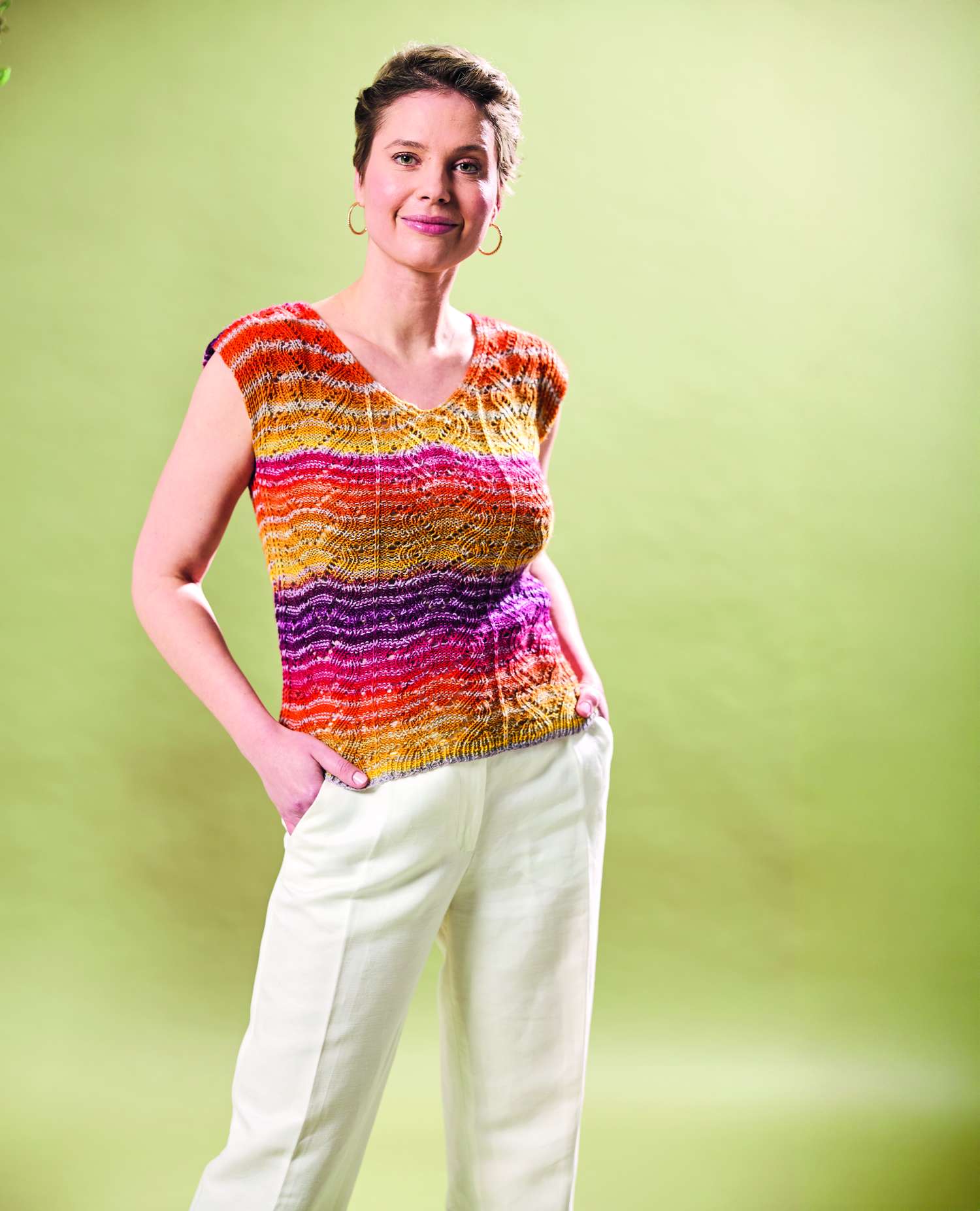 Lebhaftes Top mit Regenbogenstreifen, modisches DIY-Muster, kombiniert mit schlichten, weißen Hosen.