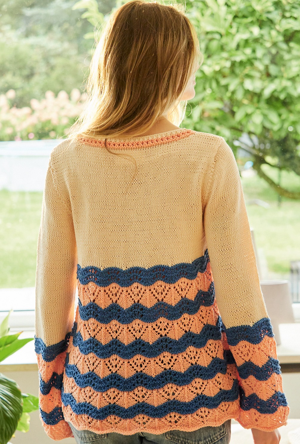Modellansicht Bild 4: Pulli mit Wellen-Ajourmuster und Trompetenärmeln in Apricot, Lachs und Blau