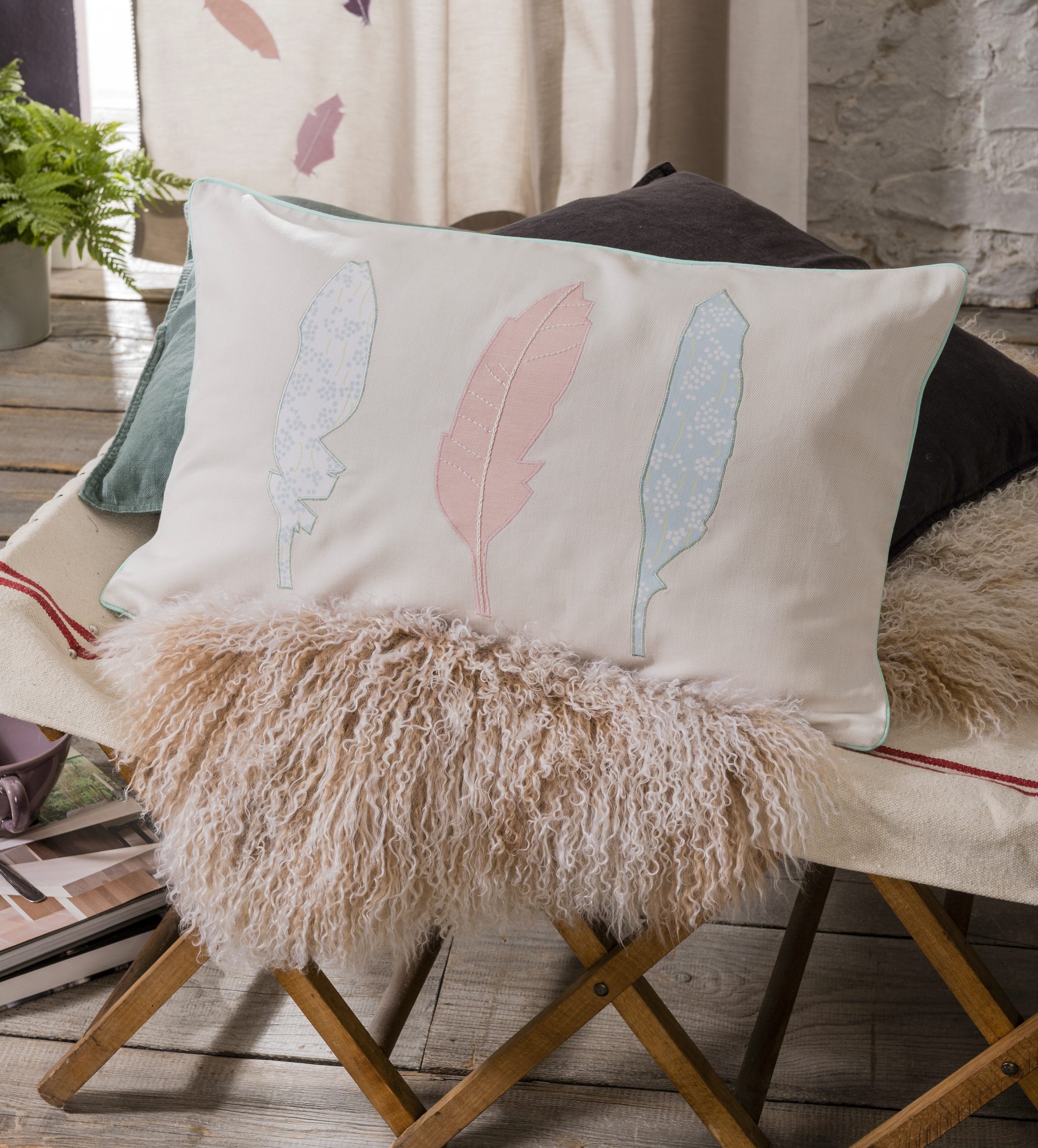 Kissen mit pastellfarbigen Federapplikationen. Zart, handgemacht, kunstvoller Touch im textilem Design.