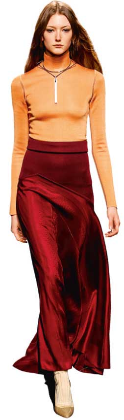 Modischer Look: Enges, orange Top trifft auf fließenden, weinroten Rock. Elegante Kombination aus Kontrastfarben.