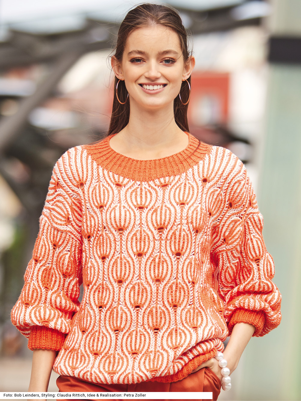 Modellansicht Bild 1: Pullover im Briochemuster in Korallenrot und Weiß