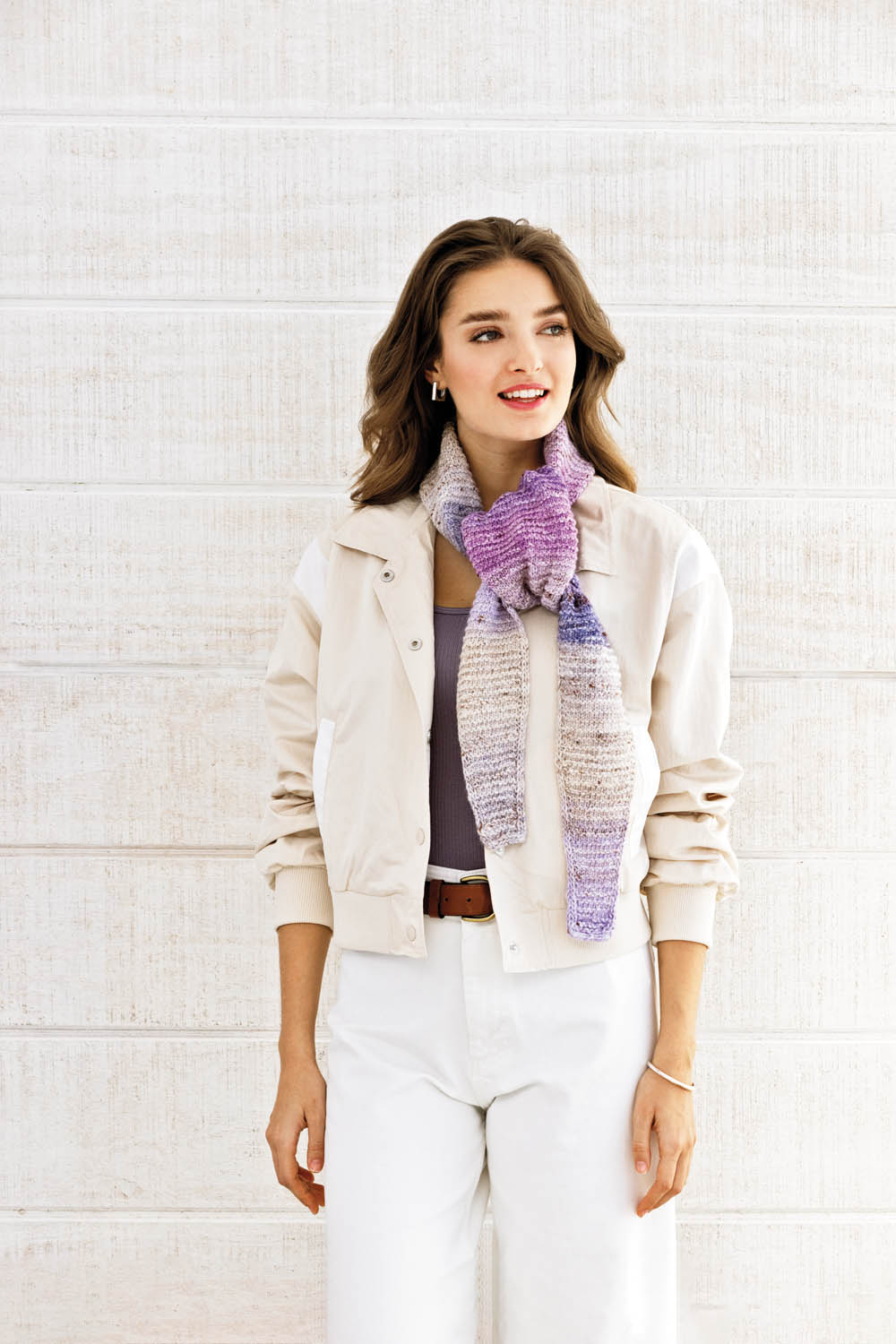 Modischer lila Strickschal, handgefertigt. Dezente Jacke, helle Hose. Farben harmonisch kombiniert.