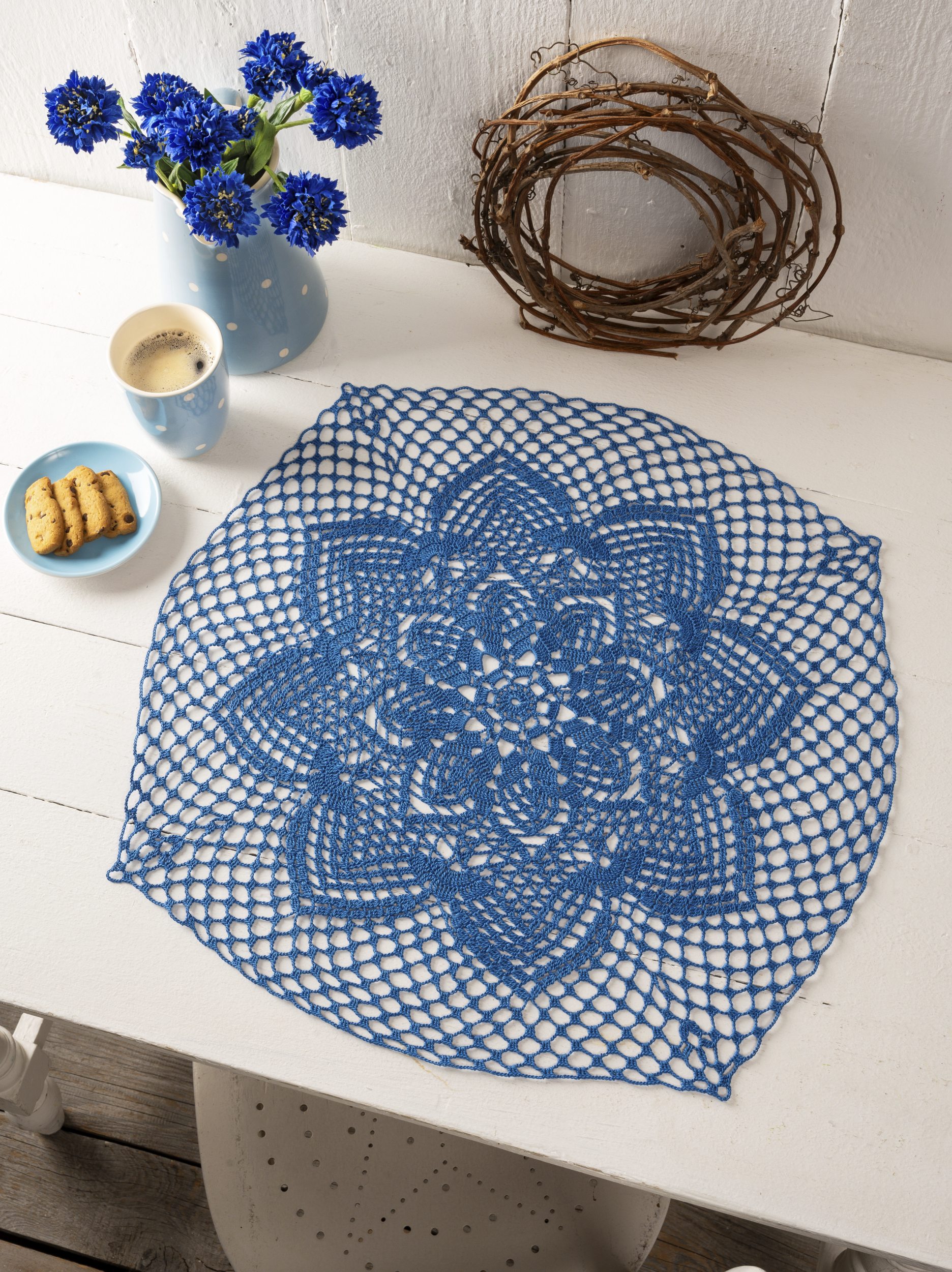 Blaues, handgemachtes Häkeldeckchen mit floralem Muster, feine Netzkonstruktion. Stilvoll und zeitlos.