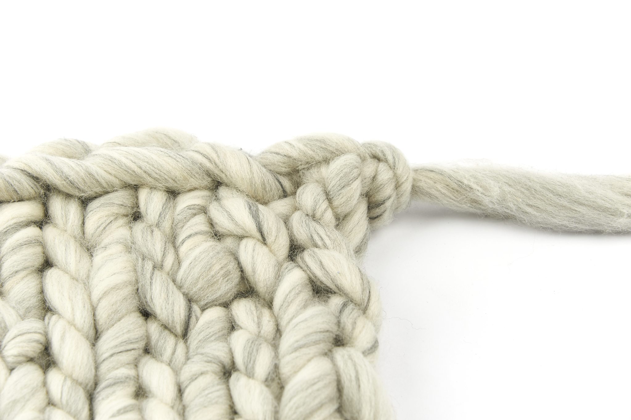 Handgemachtes, grobes Strickmuster in hellem Grau. Robustes Garn. DIY-Chic, modisch, einzigartig.
