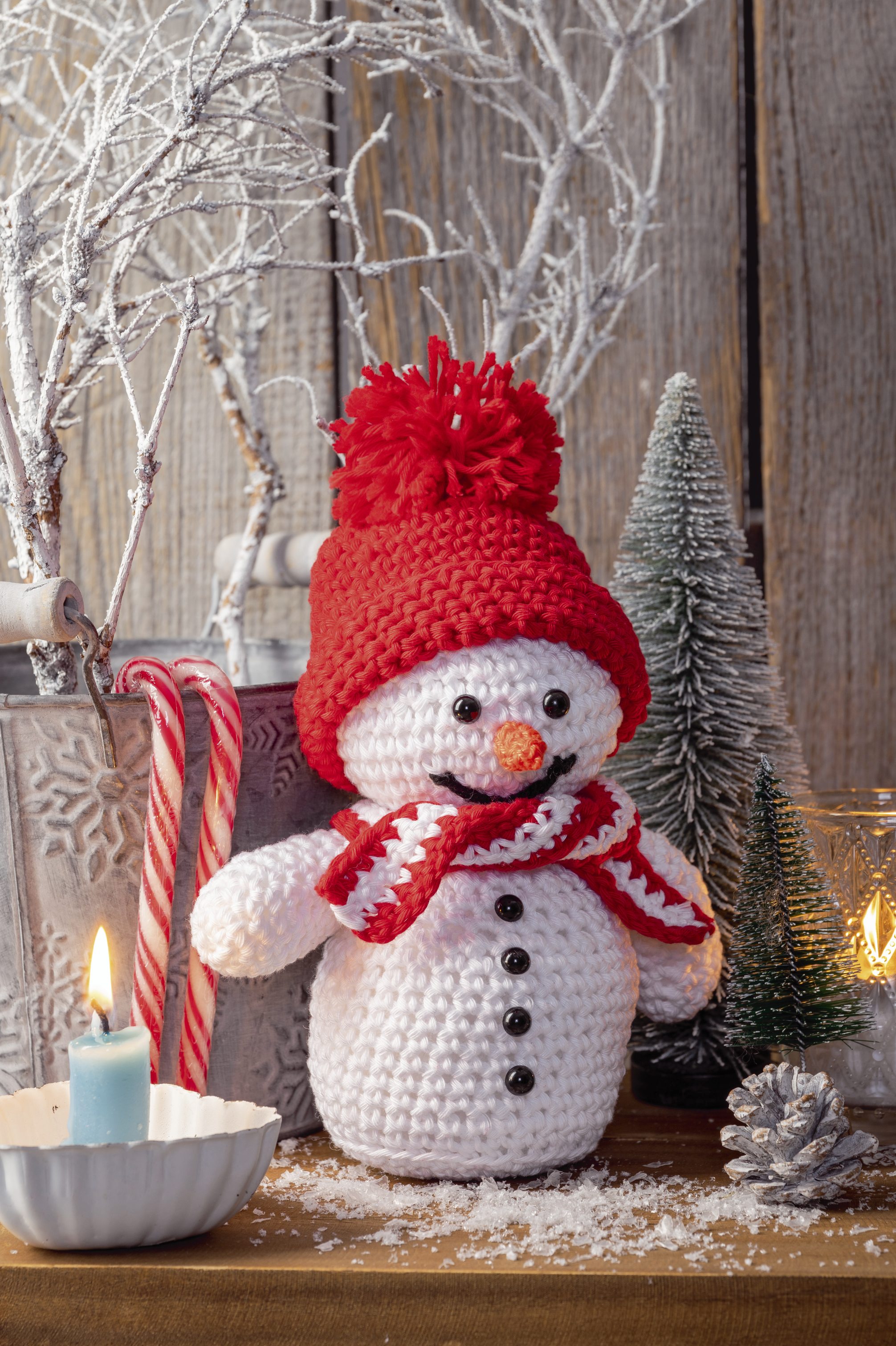 Niedlicher gehäkelter Schneemann mit roter Mütze und Schal. Farbe: Rot-Weiß. DIY, Handarbeit, verspielt.