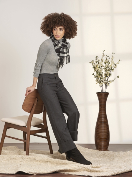 Graues Top, karierter Schal, schwarze Hose. Elegant, zeitlos, modern. Betont durch schlichte Schnitte.