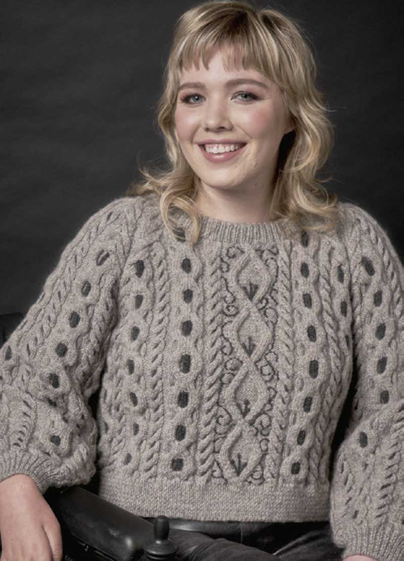 Modischer grauer Strickpullover mit Zopfmuster und Punktdetails, handgemacht, voluminöse Ärmel, vintage Look.