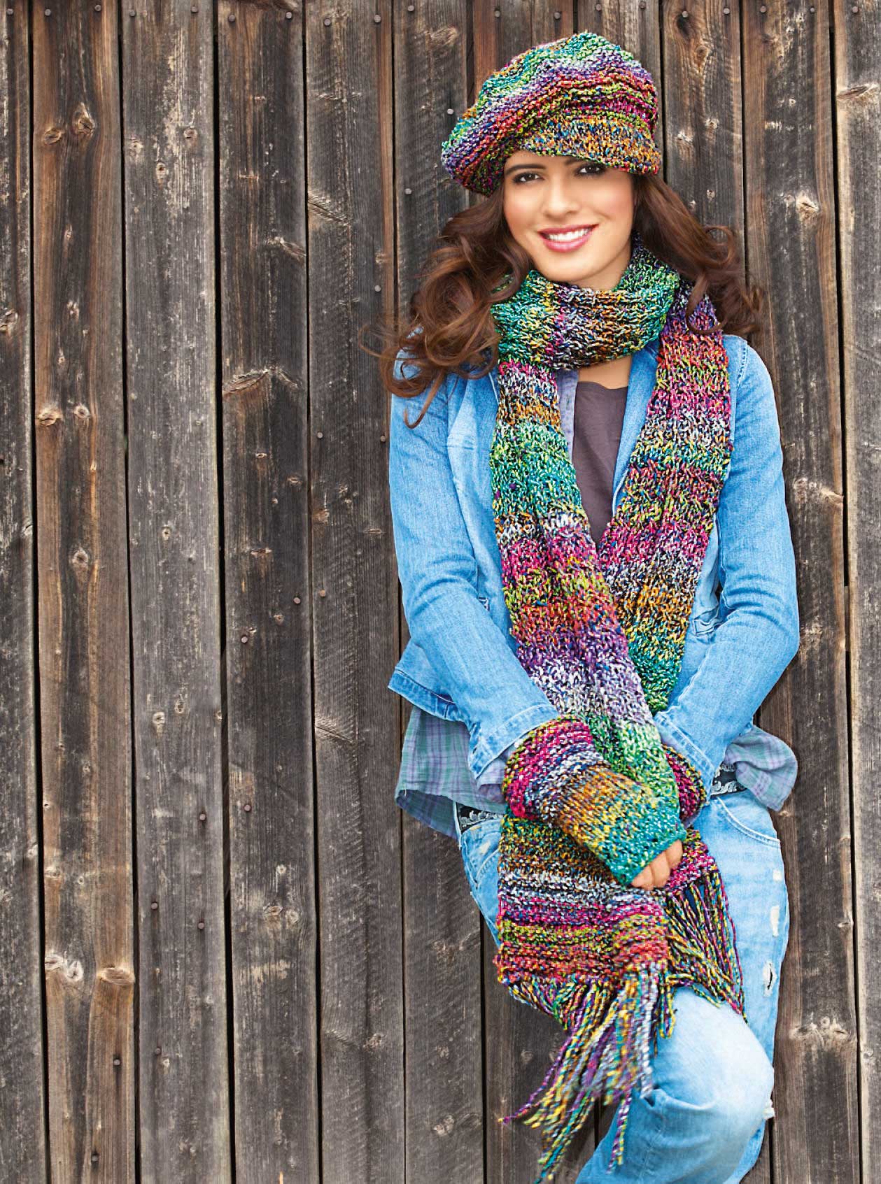 Farbiger, handgestrickter Schal und Mütze, modisch zu Jeansjacke und -hose kombiniert.