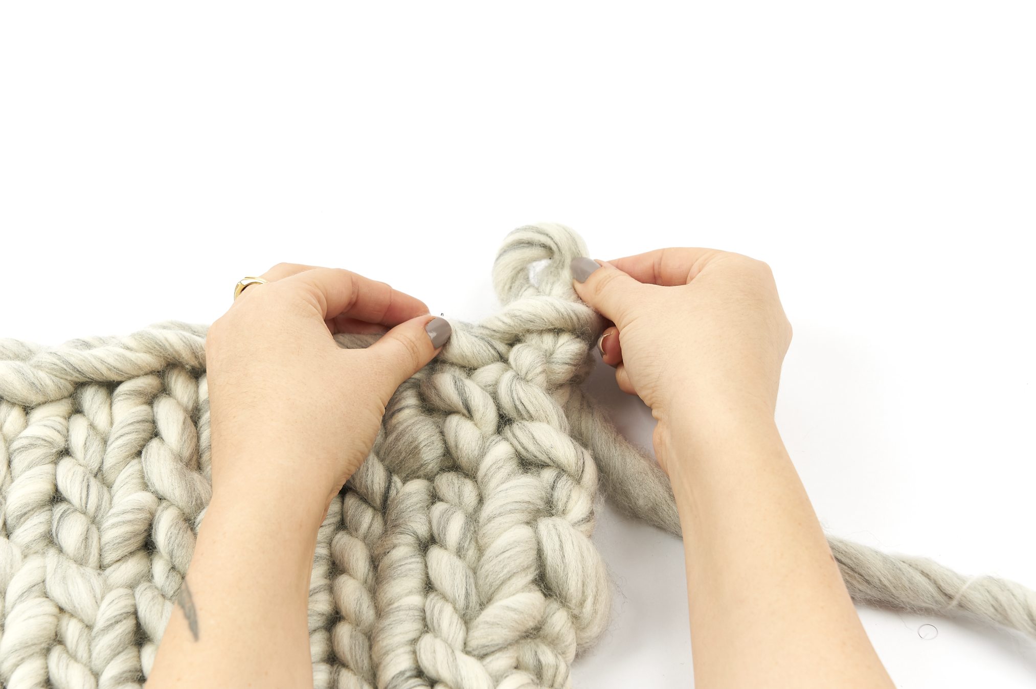 Handgemachte, grob gestrickte Maschen in Creme; modisch und kreativ, perfekte Handarbeit.