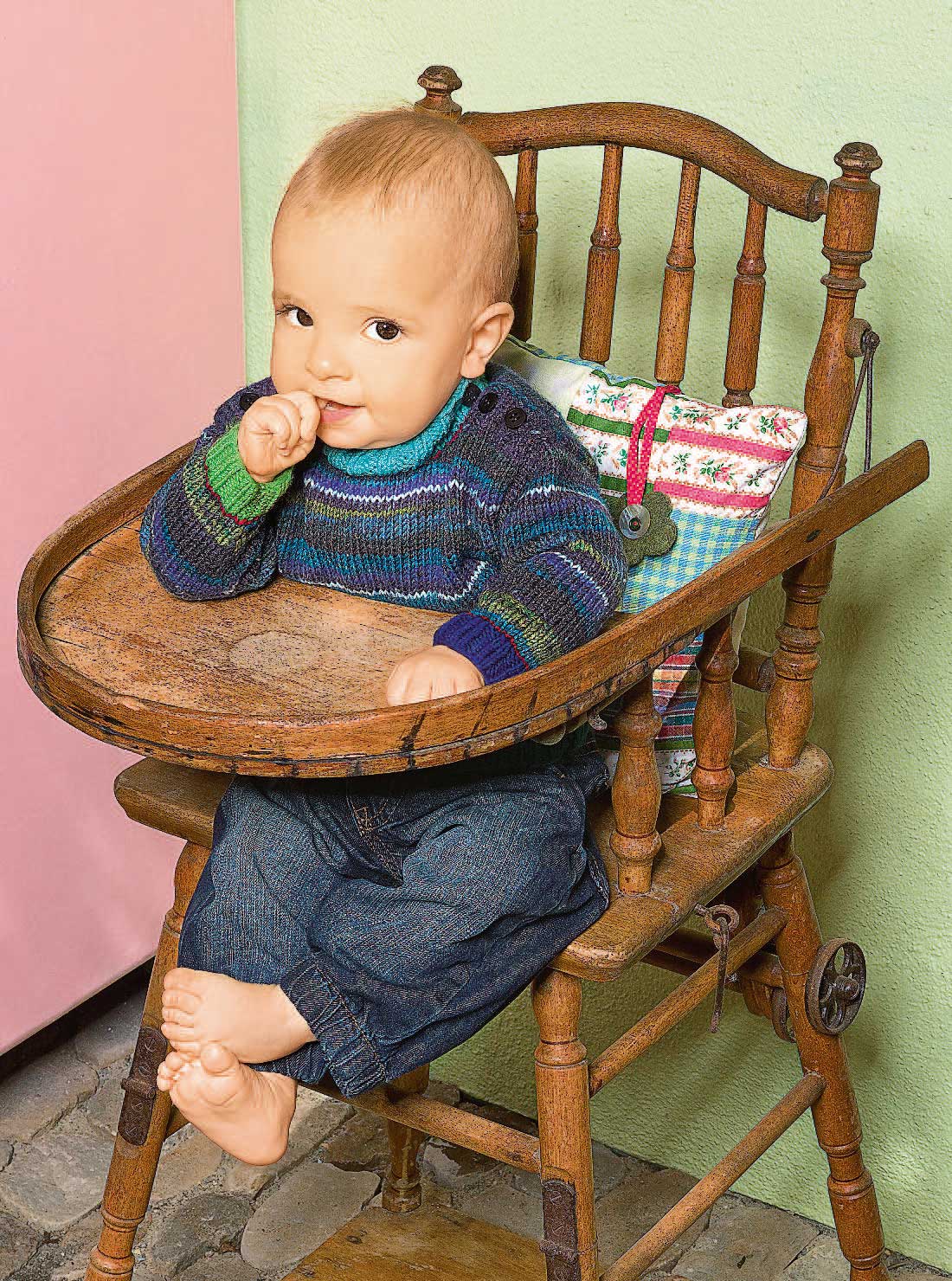 Bunter, selbstgestrickter Pullover; Jeans im lässigen Schnitt. Modisch-handgemacht.