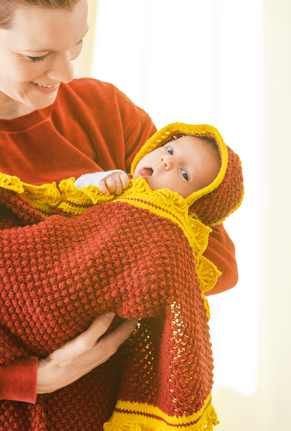 Gestrickte Babydecke mit gehäkeltem Schmuckrand und Babymütze