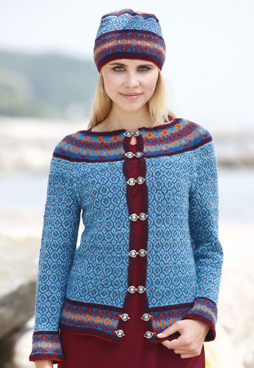 Modische, handgemachte blaue Strickjacke mit geometrischen Mustern, kombiniert mit passender Mütze.