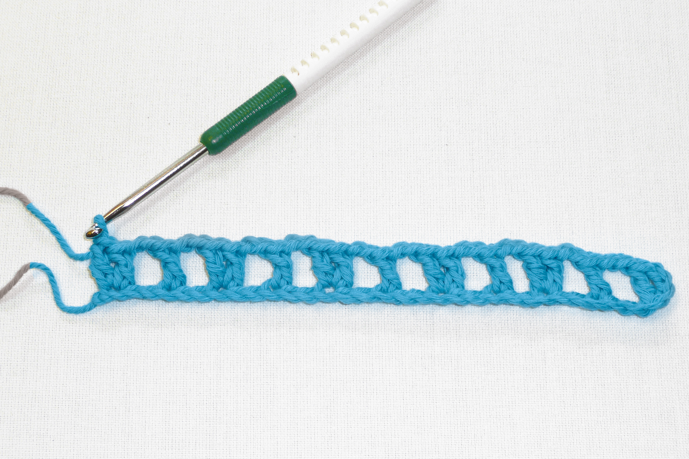 Modisches, handgemachtes Häkeldesign in leuchtendem Blau mit offenem Muster. Perfekt für DIY-Projekte.