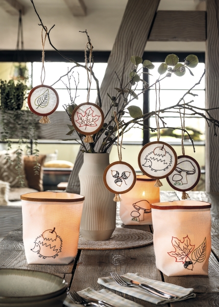 Handgemachte Laternen und Anhänger mit Herbstmotiven, minimalistisch, natürliche Farben, stilvoll, kreativ.