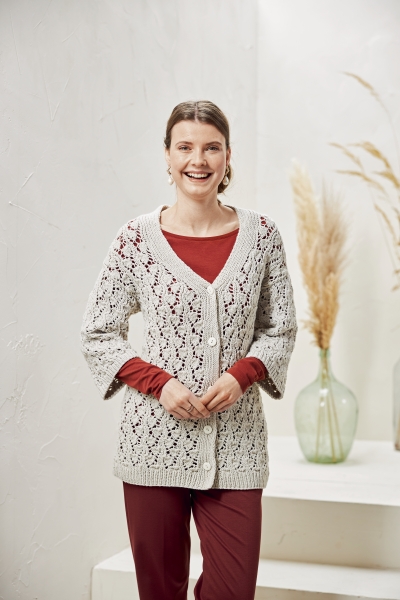 Beiger Häkel-Cardigan, lockerer Schnitt, über rotem Oberteil. Perfekte Mischung aus DIY-Chic und zeitlosem Stil.