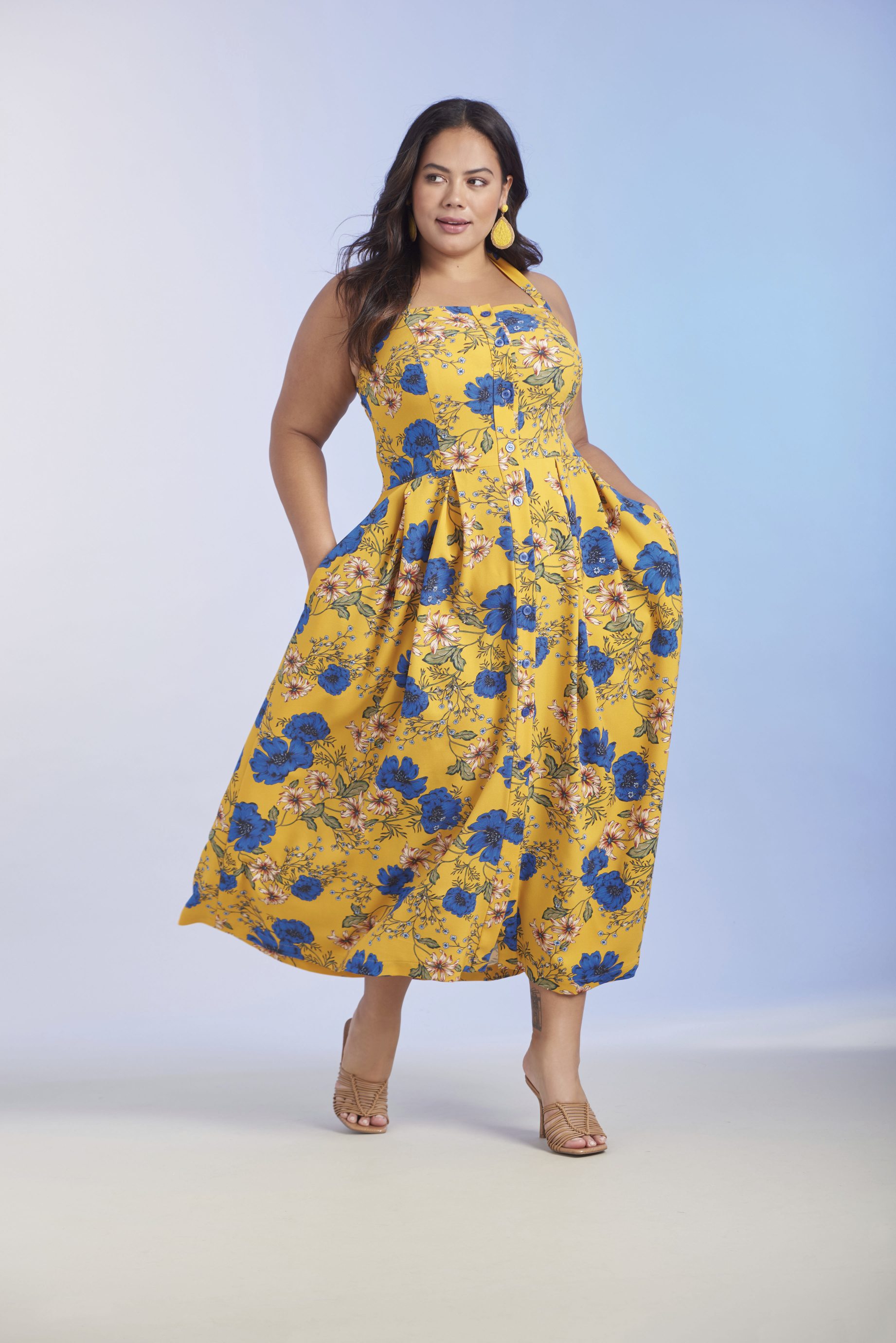Modisches gelbes Kleid mit blauen Blumen, ärmellos, knielang, taillierter Schnitt, handgefertigt wirkend.