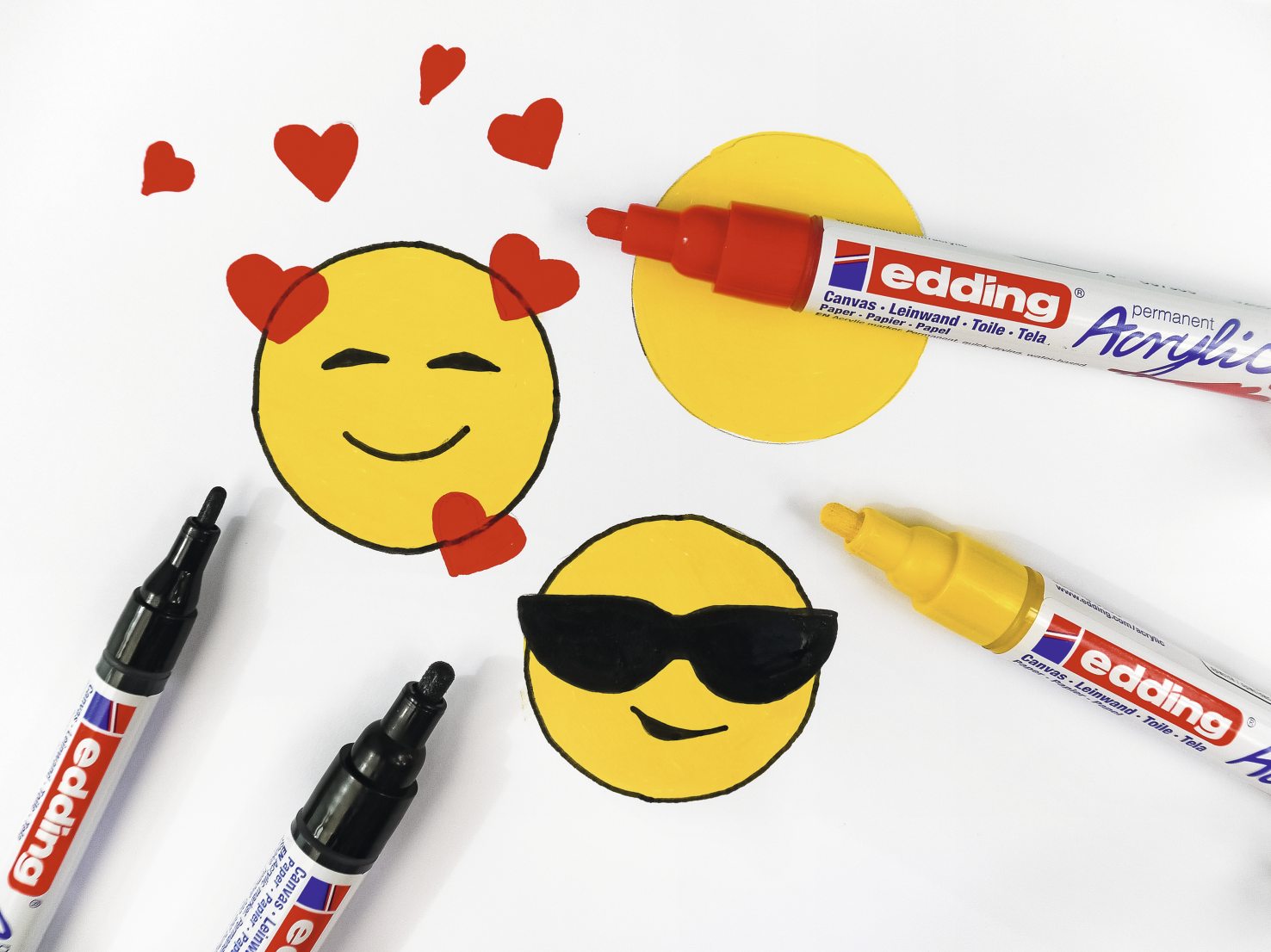 Modische Emojis, selbstgemacht mit Acrylmarkern; Herz- und Sonnenbrillen-Details; DIY-Charme.