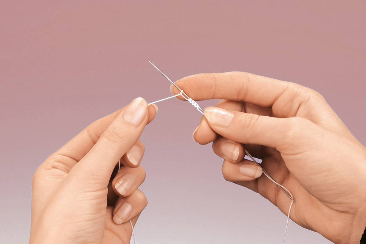 Zarte Hände beim handgemachten Weben mit feinem Garn. DIY, traditionelles Handwerk.