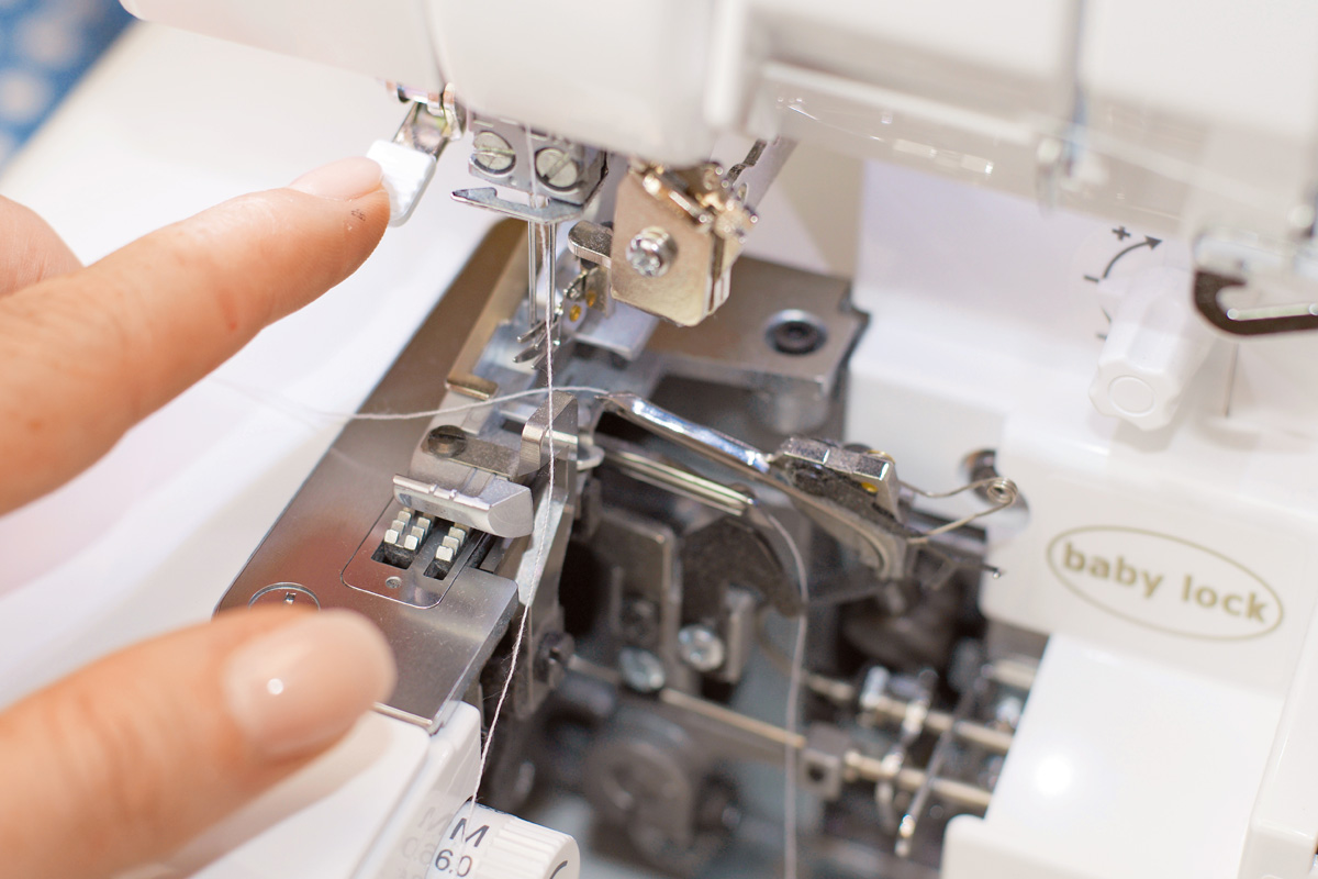 Weiße Overlock-Nähmaschine bei handgemachter Arbeit. Präzise, modisch, diy.