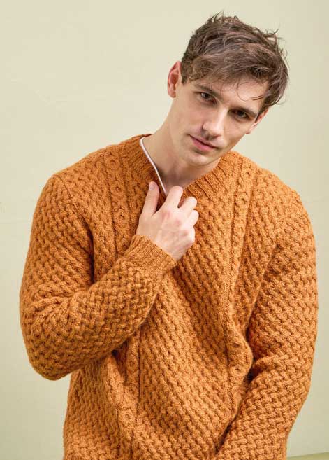 Modischer, gestrickter Pullover in warmem Ockerton, mit Zopfmuster und V-Ausschnitt, handgemacht.
