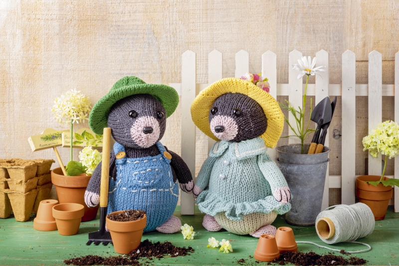 Handgemachte Strickpuppen: gelbes und grünes Hutaccessoire, modisch gekleidet mit Overalls und Kleid. DIY-Chic.