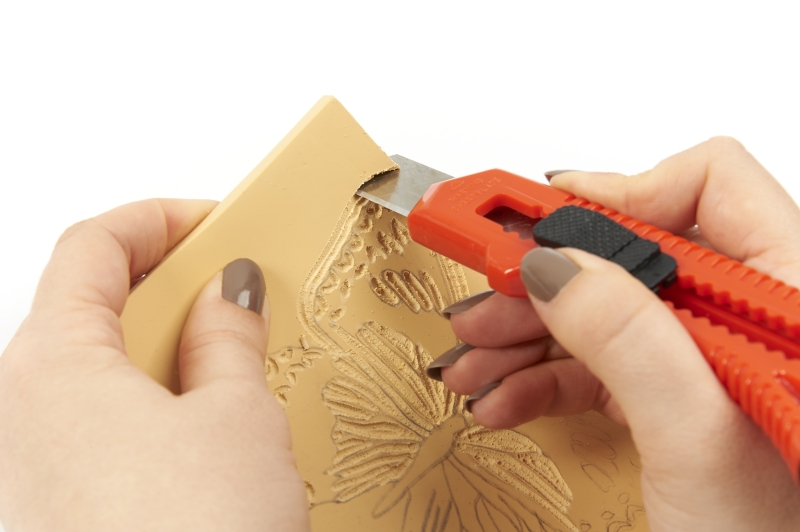 Handarbeit mit präzisem Muster in Beige-Gelb, Butterflies; rotes Schneidewerkzeug, modisch, kreativ.