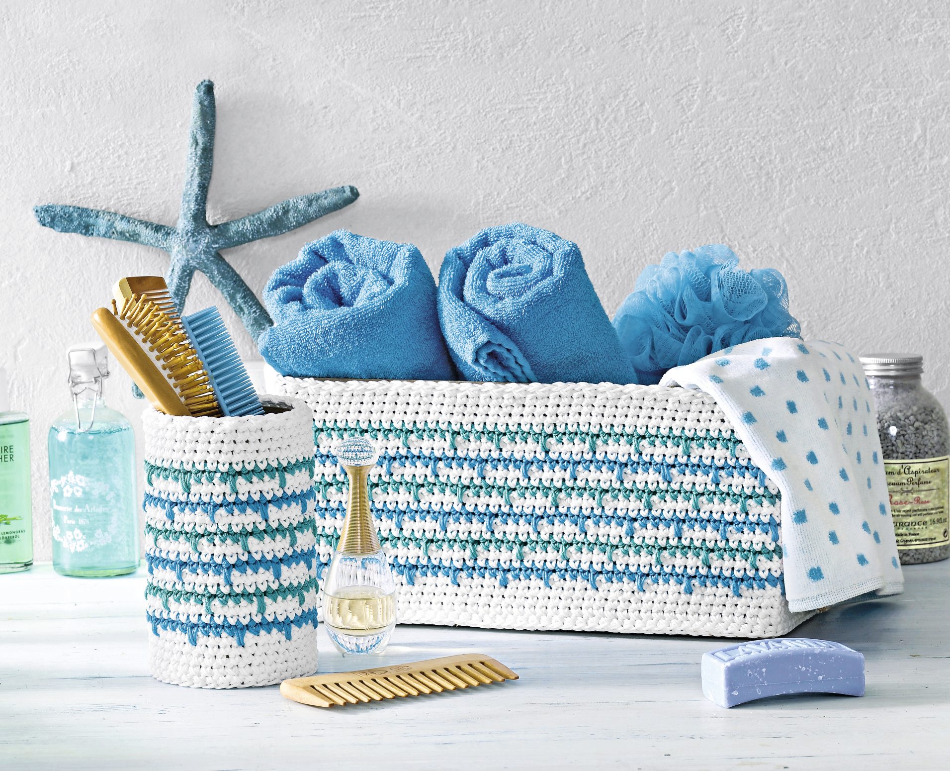 Modisch, handgemacht: Weiß-blau gestreifte Häkelkörbe mit Handtüchern. DIY-Charme im Badezimmer.
