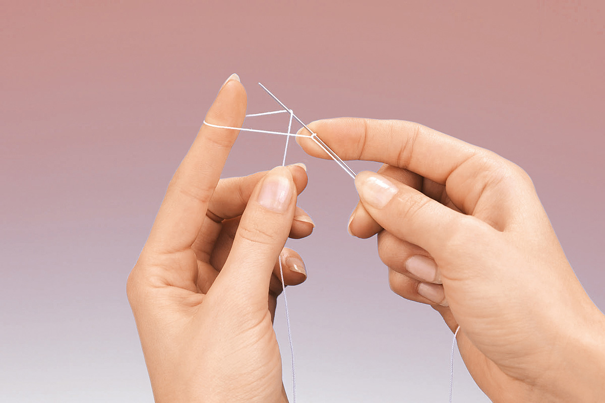 Fingerspitzen halten weiße Wolle beim Stricken. DIY, Handarbeit, elegant, minimalistisch.