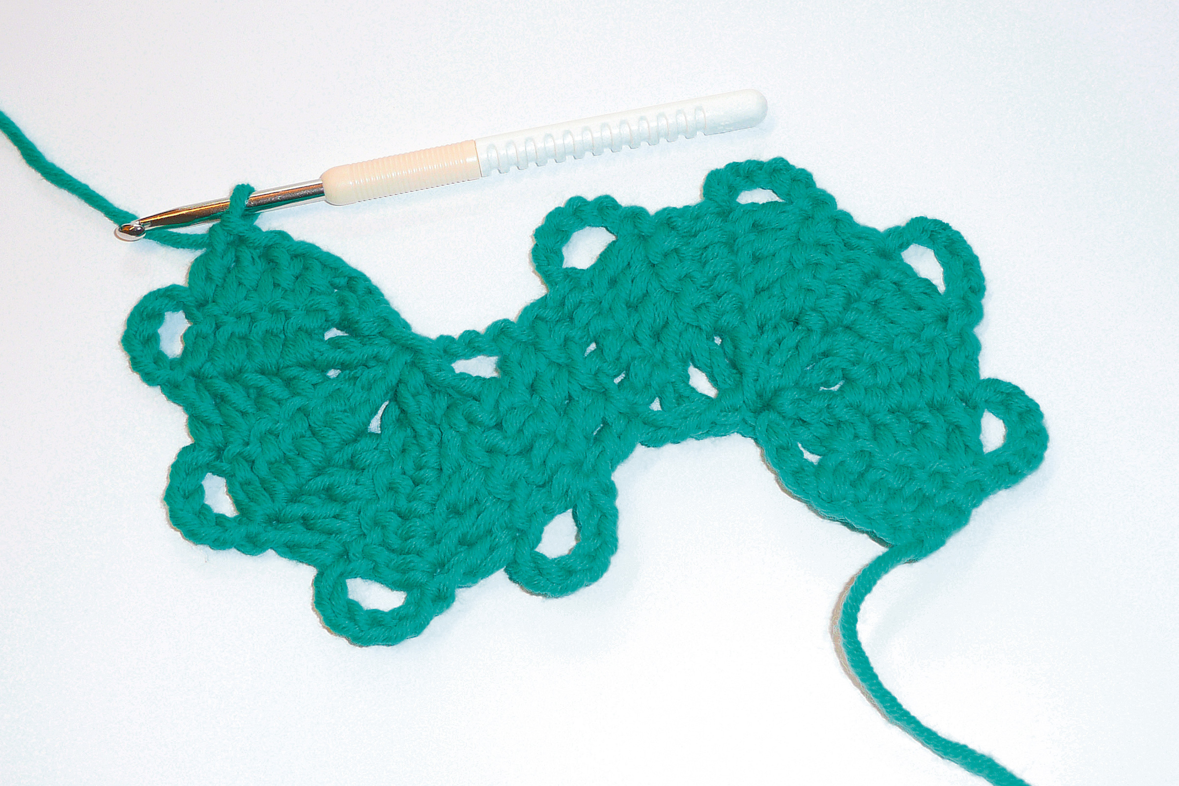 Handgemachtes türkises Häkelstück, wellenförmiges Muster, modisch, DIY, perfekte Handarbeit.