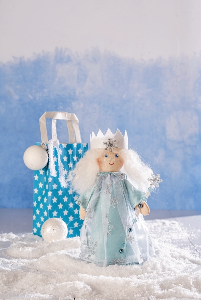 Handgemachte Puppe in blauem Kleid mit Schneeflocken-Muster, glitzerndem Tüll und Krone. Modisch und kreativ.