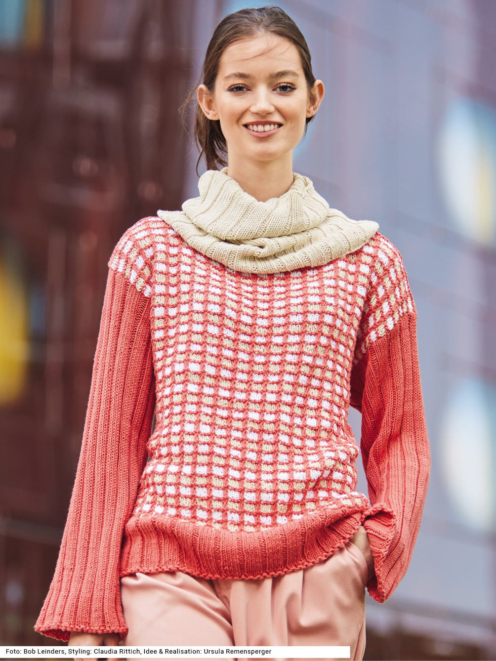 Modellansicht Bild 1: Pulli mit Hebemaschenmuster in Lachsrot, Leinenfarbe und Weiß und Loop im Rippenmuster in Leinenfarbe