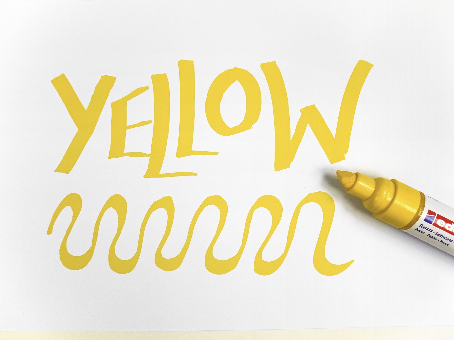 Gelber Marker-Schriftzug, geschwungenes Design. Lebendig, kreativ, handgemacht.