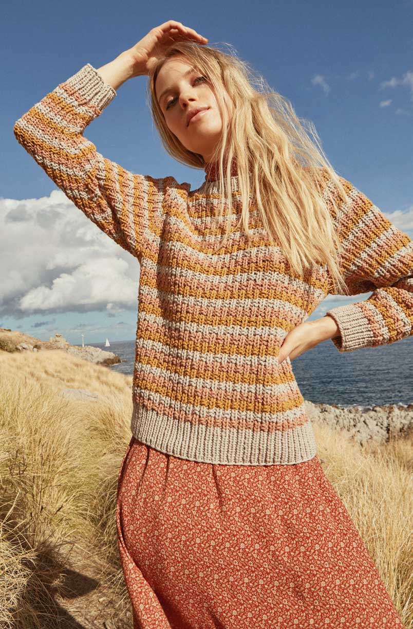 Modischer, handgemachter Pullover in Erdtönen, gestreift. Langer Rock mit floralen Mustern, ideal für den Herbst.