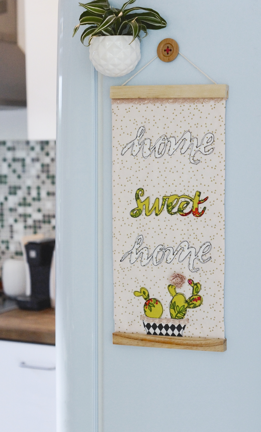 Modisches DIY-Muster, niedliche Kakteen. Schriftzug: 'Home Sweet Home', kunstvoll gestickt auf heller Leinwand.