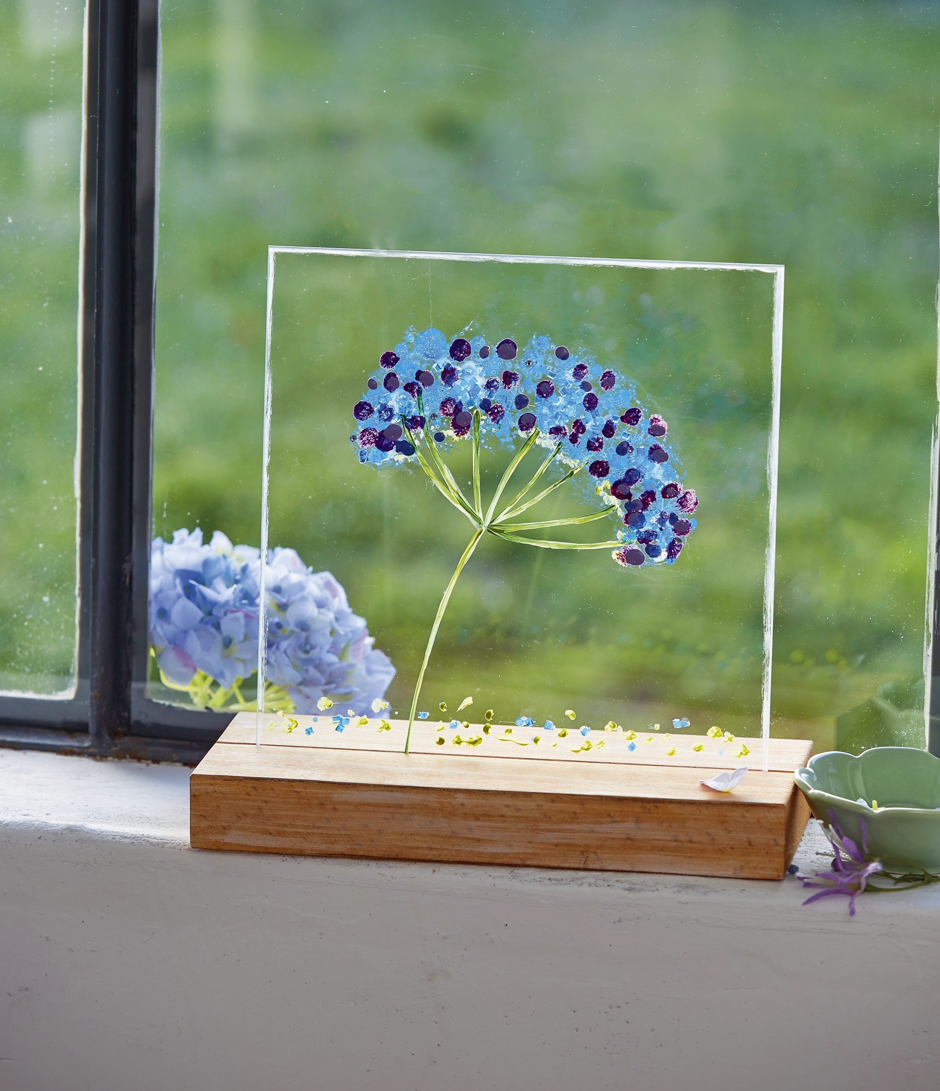Handgemachte Blumen auf Glas, farbenfroh, zart, DIY-Charme. Holzsockel für natürlichen Look.
